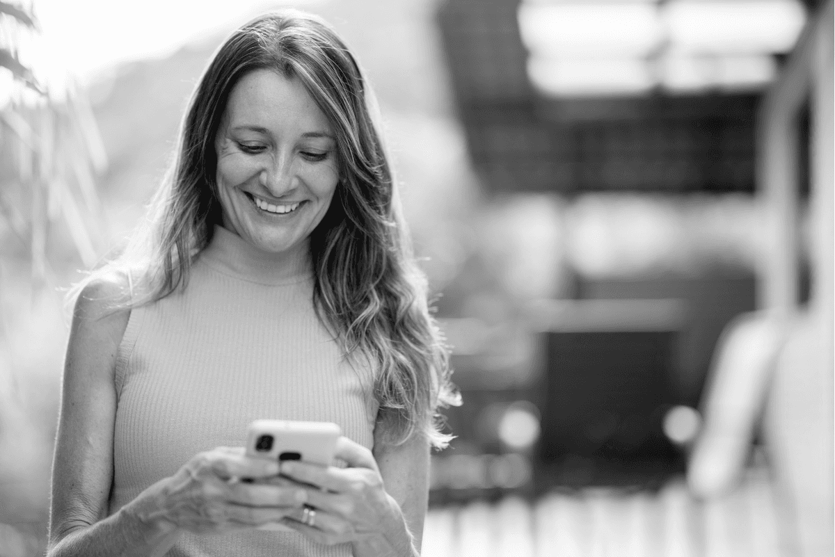 Woman using Resilia mental wellness companion app on her phone for stress and anxiety support